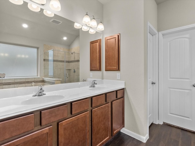 bathroom featuring walk in shower, lofted ceiling, vanity, and hardwood / wood-style floors