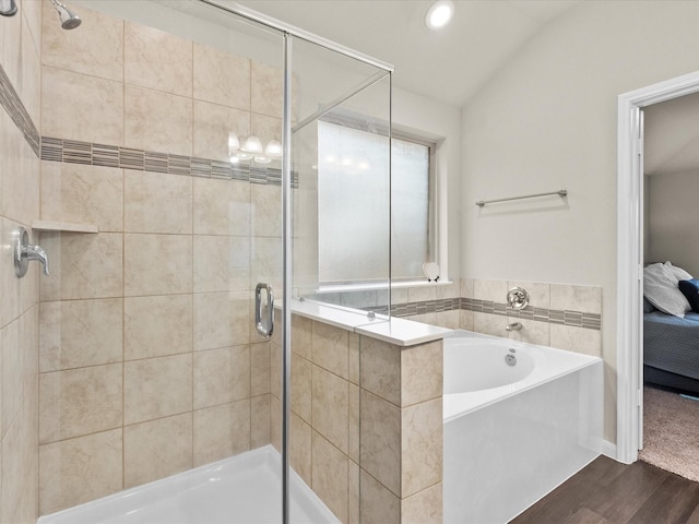 bathroom with hardwood / wood-style flooring, plus walk in shower, and vaulted ceiling