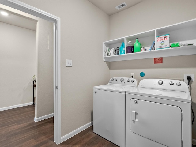 clothes washing area with separate washer and dryer and dark wood-type flooring