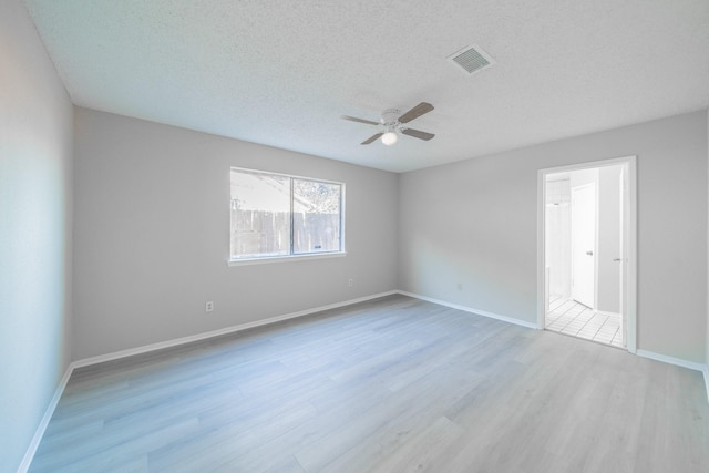 empty room with ceiling fan, light hardwood / wood-style floors, and a textured ceiling