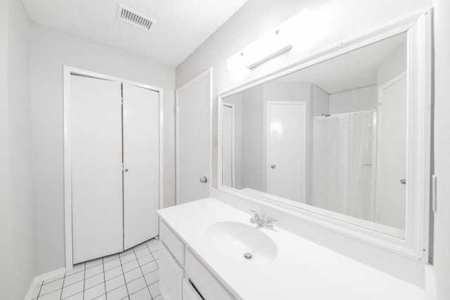 bathroom featuring tile patterned flooring, vanity, a textured ceiling, and a shower with curtain