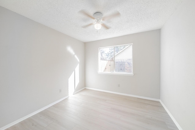 spare room featuring a textured ceiling, ceiling fan, and light wood-type flooring