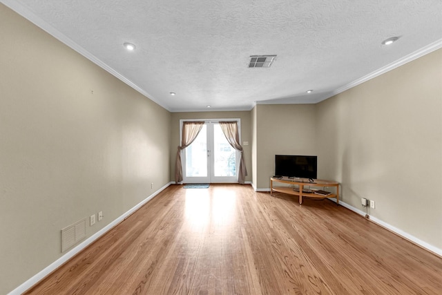 unfurnished living room featuring crown molding, a textured ceiling, light hardwood / wood-style floors, and french doors