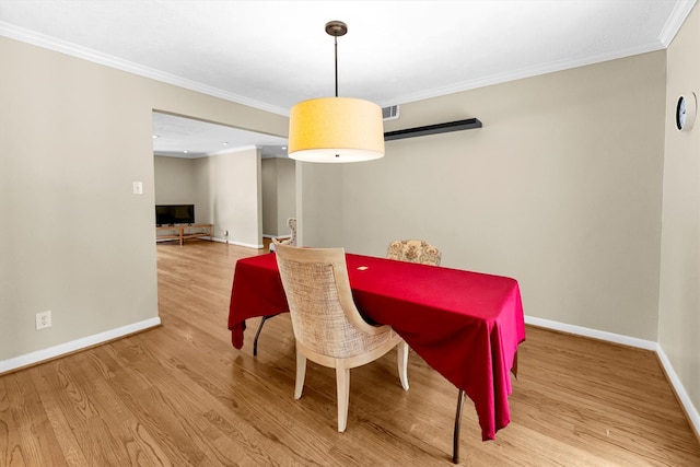 dining space with ornamental molding and hardwood / wood-style floors