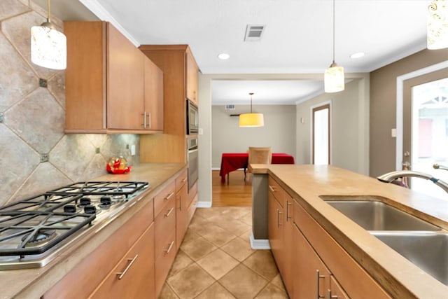 kitchen featuring pendant lighting, sink, light tile patterned floors, stainless steel appliances, and tasteful backsplash