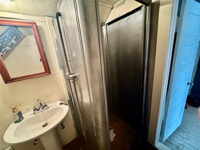 bathroom with a shower with door and sink