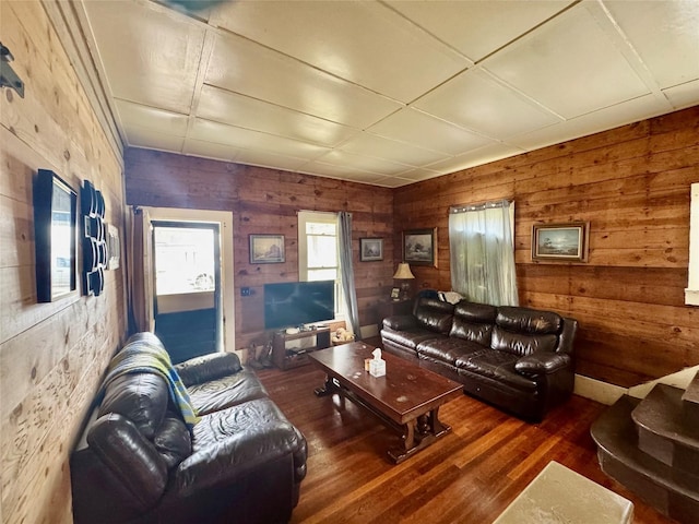 living room featuring dark wood-type flooring and wooden walls