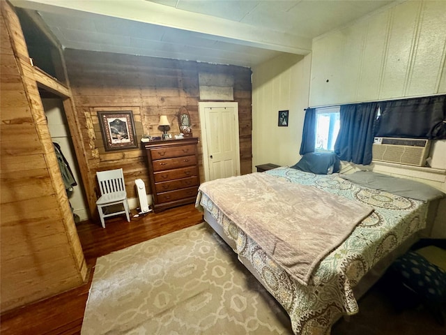 bedroom with cooling unit, wood-type flooring, and beam ceiling