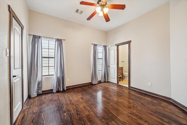 unfurnished bedroom with ceiling fan, ensuite bathroom, and dark hardwood / wood-style flooring