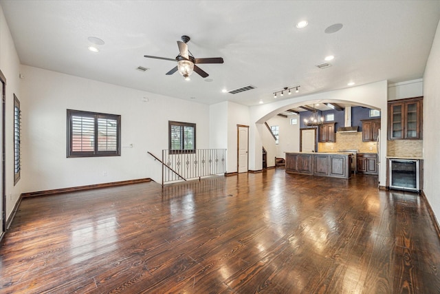 unfurnished living room with wine cooler, dark hardwood / wood-style flooring, and ceiling fan