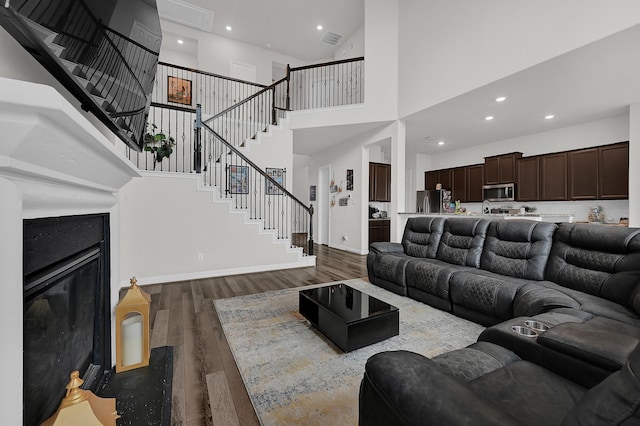 living room with a towering ceiling and hardwood / wood-style floors