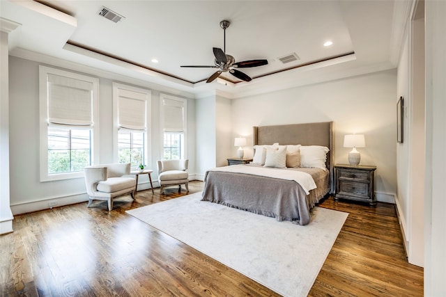 bedroom featuring crown molding, ceiling fan, a tray ceiling, and dark hardwood / wood-style flooring