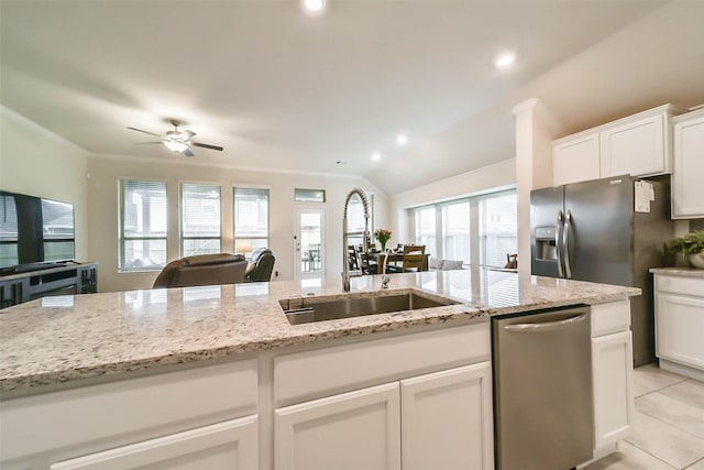 kitchen with white cabinetry, stainless steel appliances, sink, and light stone counters