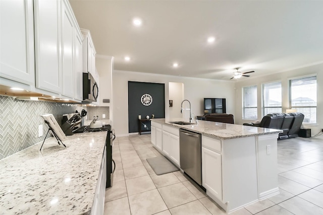 kitchen with white cabinetry, sink, stainless steel appliances, and a center island with sink