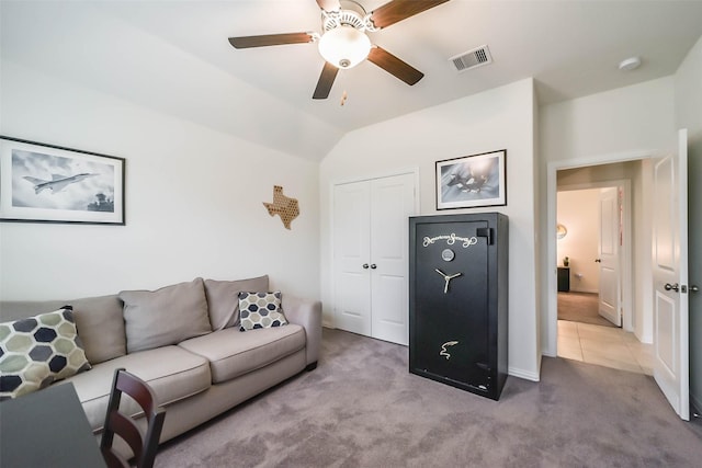 living room with ceiling fan, vaulted ceiling, and light carpet