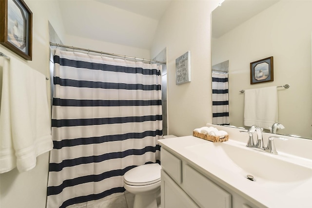 bathroom with vaulted ceiling, tile patterned flooring, vanity, walk in shower, and toilet