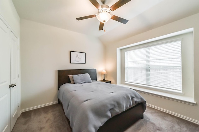 carpeted bedroom featuring vaulted ceiling, a closet, and ceiling fan