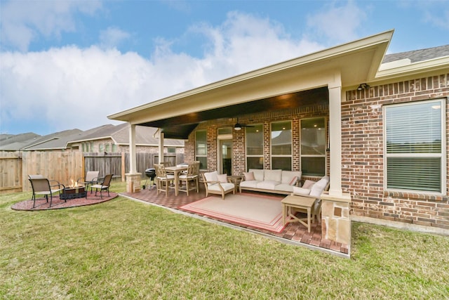 back of house featuring a lawn, an outdoor living space with a fire pit, and a patio area