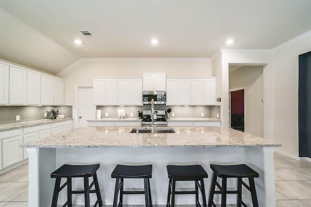 kitchen with white cabinetry, appliances with stainless steel finishes, sink, and an island with sink