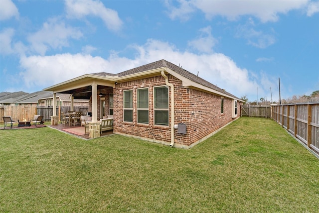 rear view of property with a patio, a yard, and ceiling fan