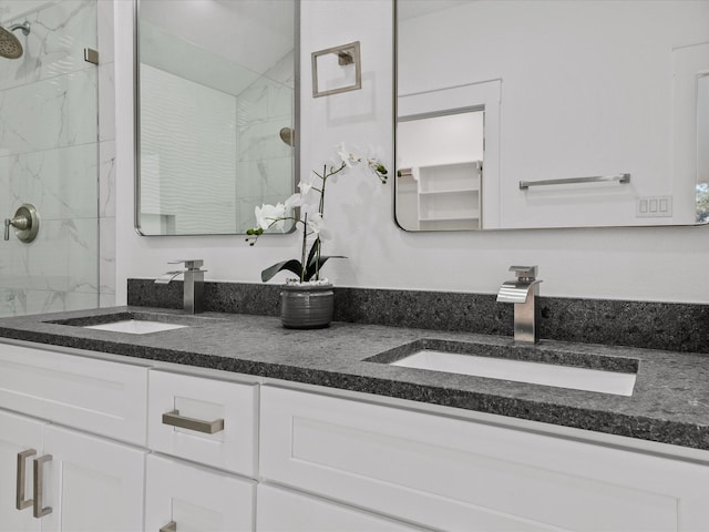 bathroom with a tile shower and vanity