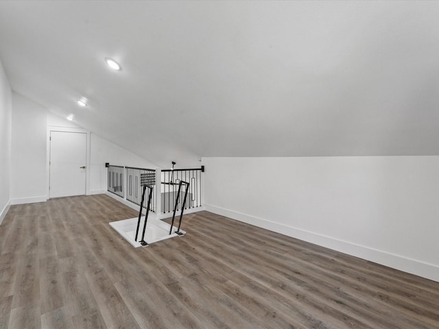 bonus room with hardwood / wood-style flooring and vaulted ceiling