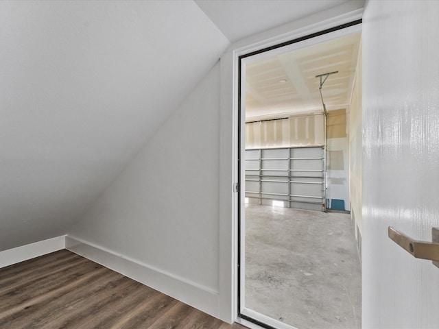 bonus room featuring dark wood-type flooring and vaulted ceiling