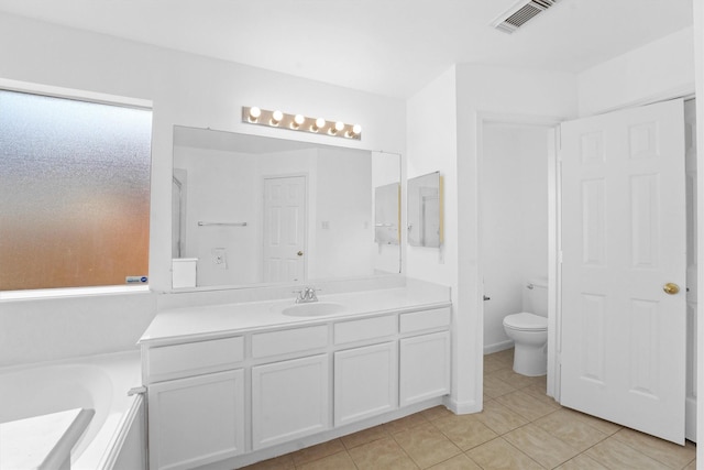 bathroom with tile patterned flooring, vanity, a bathing tub, and toilet