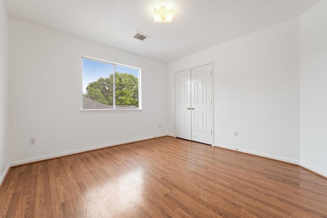 unfurnished room with wood-type flooring