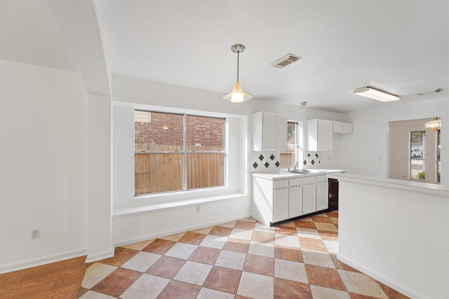 kitchen featuring hanging light fixtures and white cabinetry