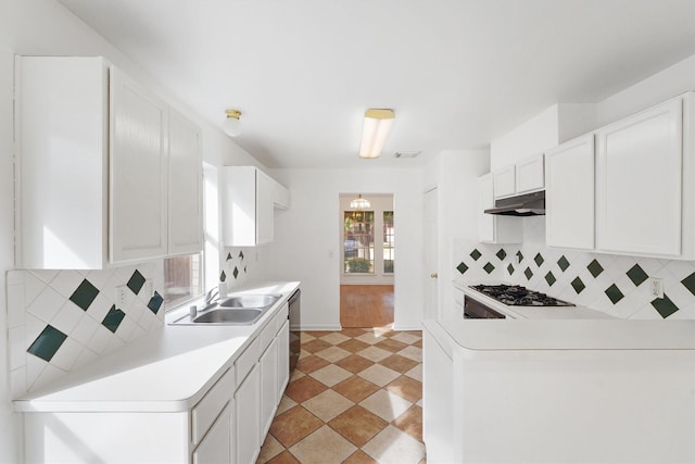 kitchen featuring sink, gas cooktop, black dishwasher, white cabinets, and backsplash