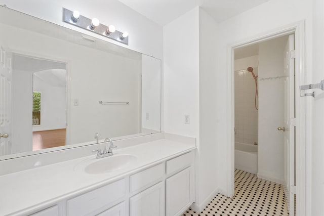 bathroom with tiled shower / bath and vanity