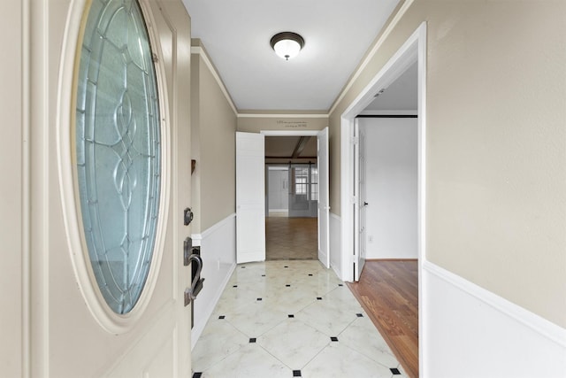 foyer entrance featuring crown molding and light hardwood / wood-style floors