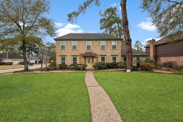 colonial-style house featuring a front lawn