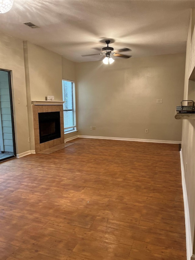 3500 Tangle Brush Dr Unit 195, The Woodlands, TX 77381 - unfurnished living room with hardwood / wood-style floors, a textured ceiling, a fireplace, and ceiling fan