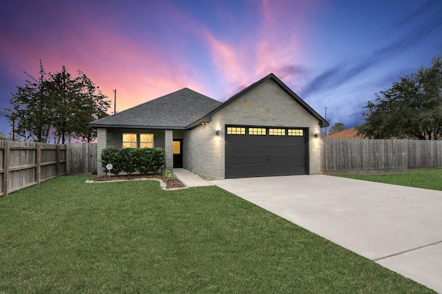 view of front of property with a garage and a yard