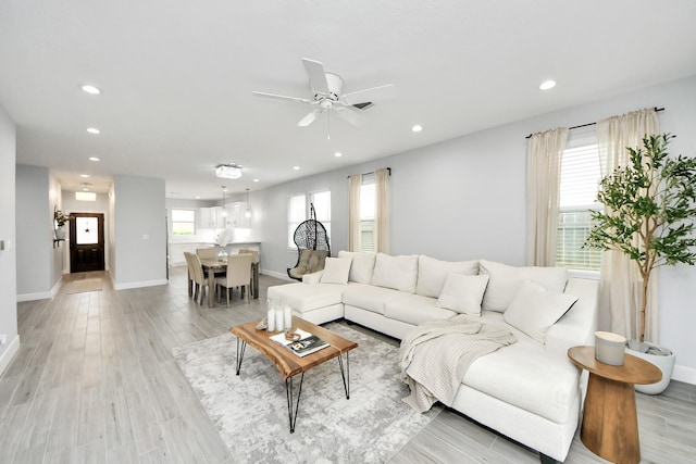 living room featuring ceiling fan and light hardwood / wood-style flooring