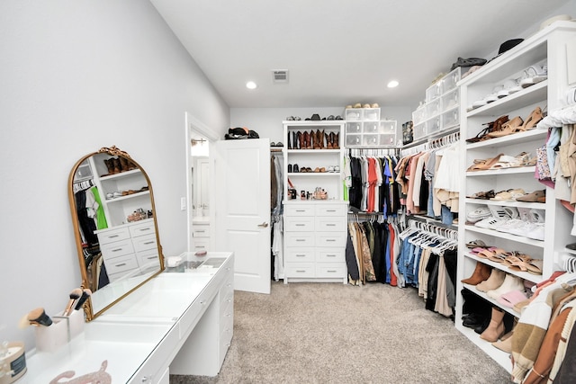 walk in closet with light colored carpet