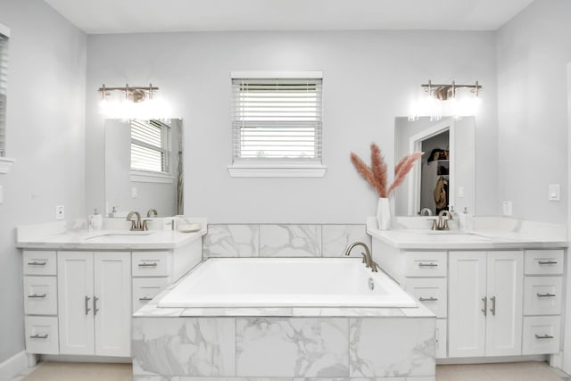 bathroom with vanity and tiled tub