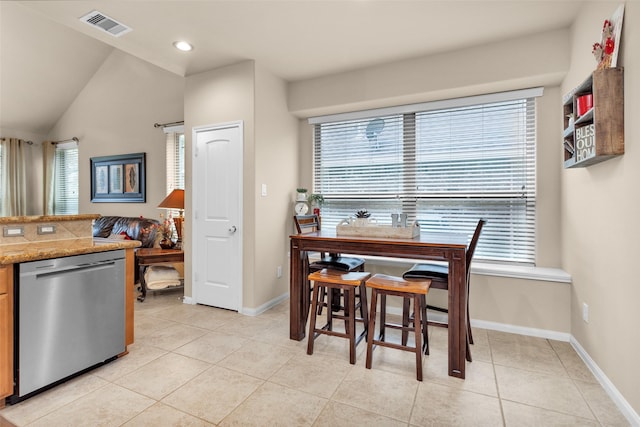 tiled dining area with vaulted ceiling and a healthy amount of sunlight