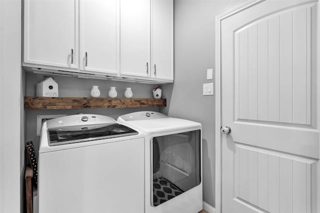 laundry room featuring separate washer and dryer and cabinets