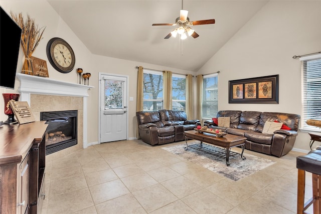 tiled living room featuring ceiling fan, a tiled fireplace, and high vaulted ceiling