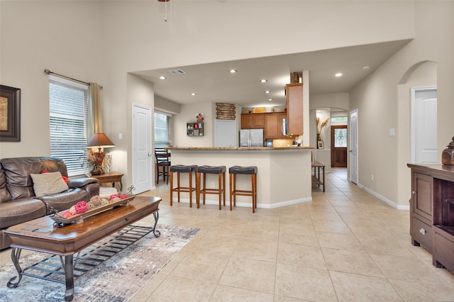 tiled living room featuring a high ceiling