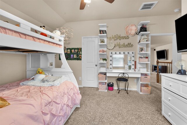 carpeted bedroom with lofted ceiling, built in desk, and ceiling fan