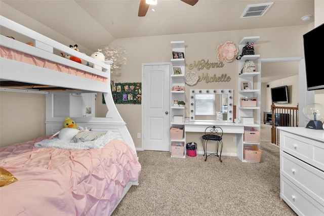 carpeted bedroom featuring lofted ceiling, built in desk, and ceiling fan