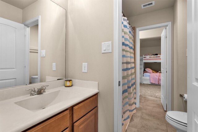 bathroom featuring vanity, tile patterned flooring, and toilet