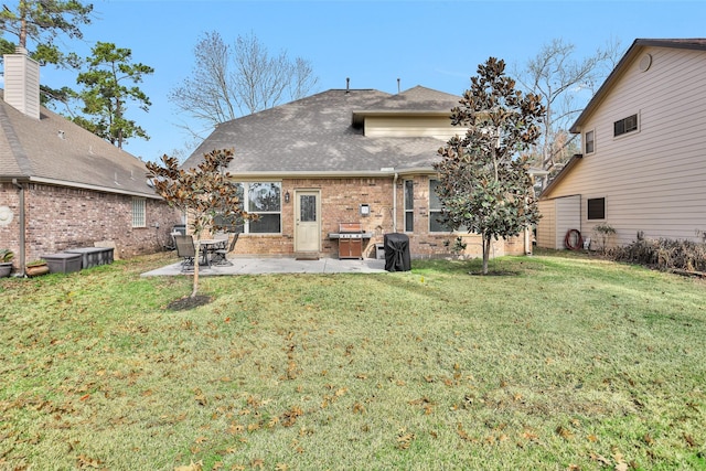 back of property featuring a yard and a patio