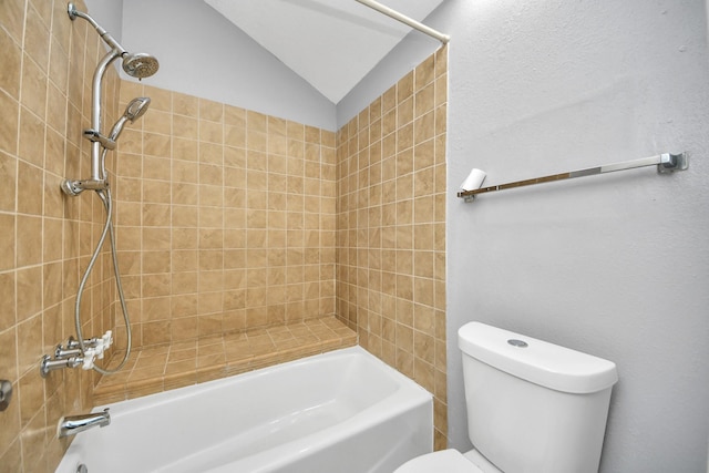 bathroom featuring lofted ceiling, toilet, and tiled shower / bath combo