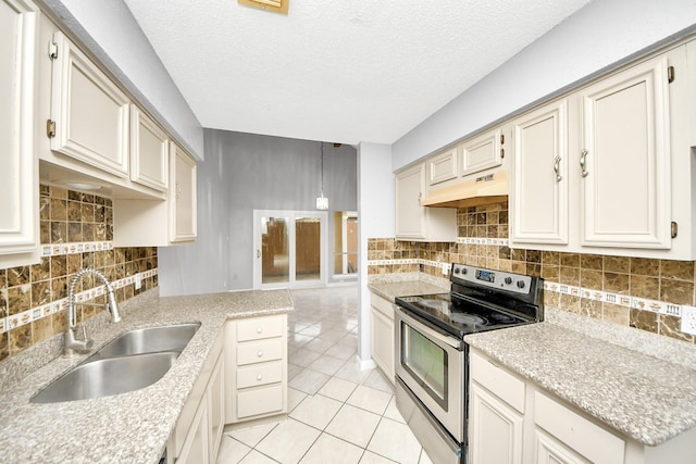 kitchen with stainless steel electric stove, tasteful backsplash, sink, light tile patterned floors, and cream cabinets