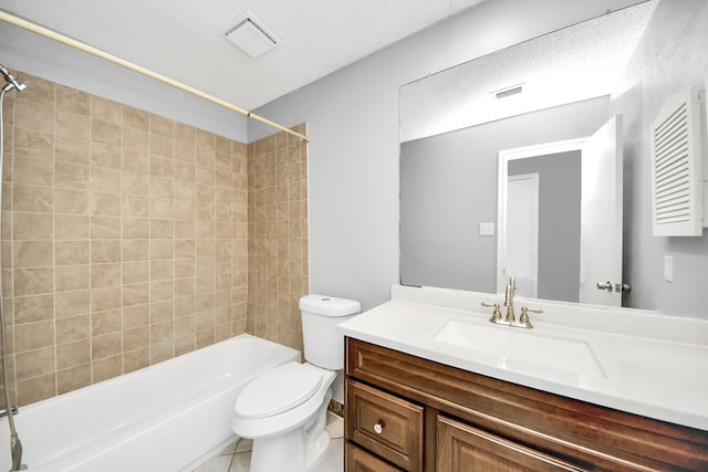 full bathroom with toilet, tiled shower / bath, a textured ceiling, vanity, and tile patterned flooring